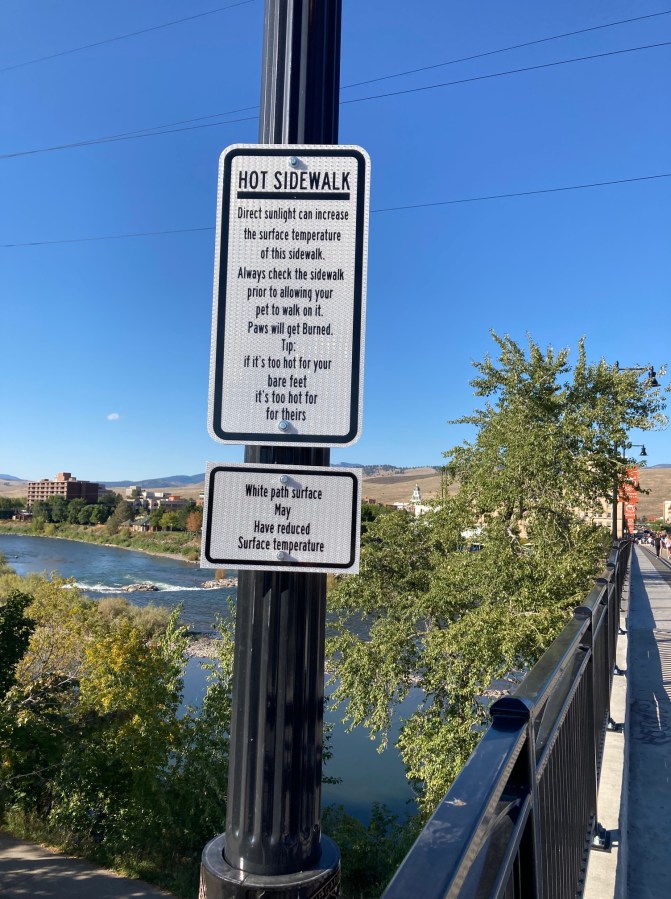 A sign warns of pavement too hot for dog feet
